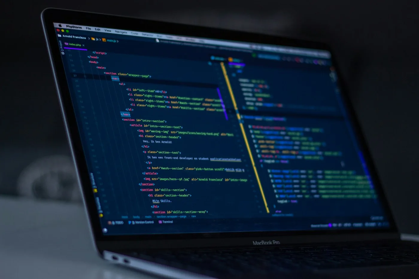 A laptop showing source code in a dark development environment